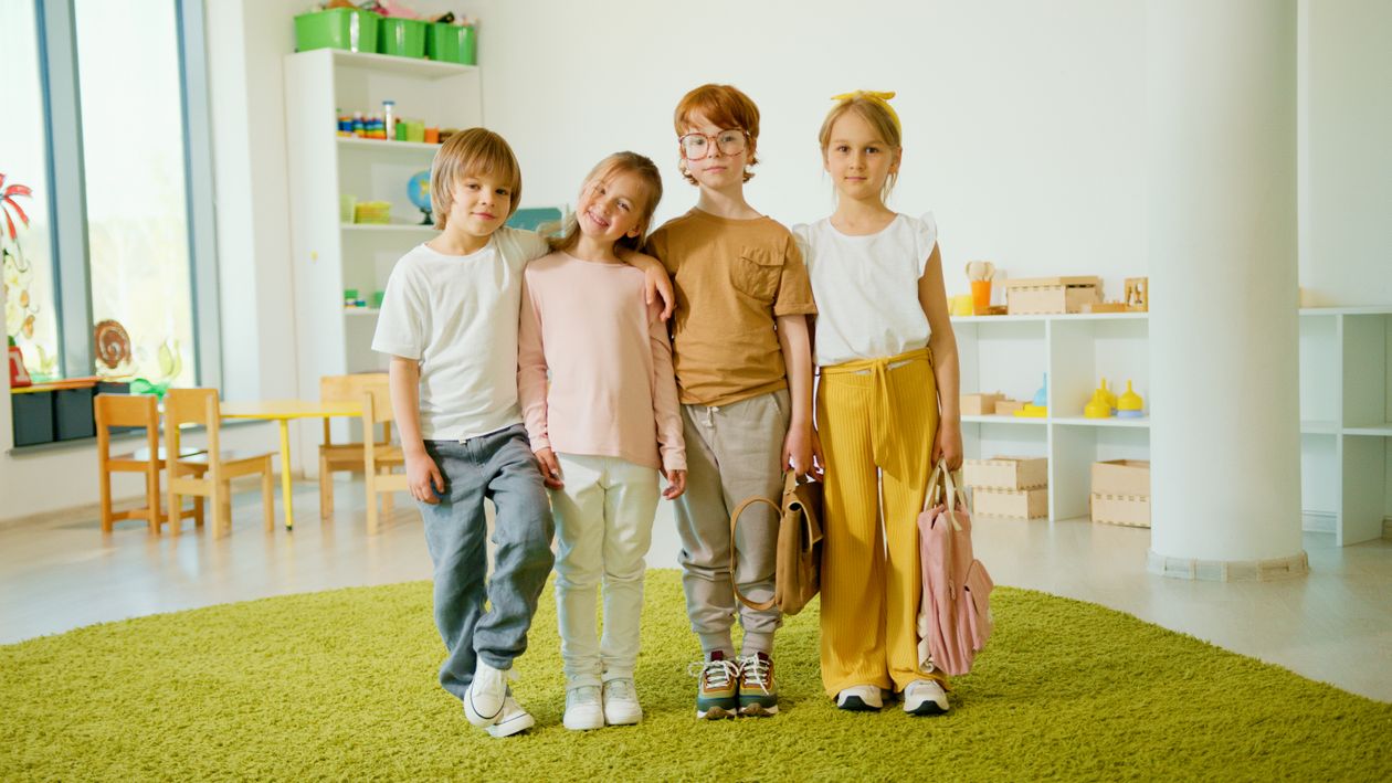 Children standing together in a bright classroom.